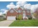 Two-story brick home with blue shutters, manicured lawn, and attached two car garage at 1903 Yellowwood Ln, Durham, NC 27712