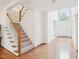 Bright foyer with hardwood floors, a staircase with carpeted steps, and natural light from the large window at 1903 Yellowwood Ln, Durham, NC 27712