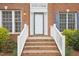 Exterior shot of the brick front porch with white railing and the front door with side windows at 1903 Yellowwood Ln, Durham, NC 27712