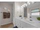 A bathroom with double sink vanity, large mirror, and tile flooring at 203 Grassy Point Rd, Apex, NC 27502