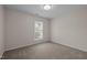 A carpeted bedroom with neutral walls and a single window at 203 Grassy Point Rd, Apex, NC 27502