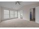 A spacious main bedroom with multiple windows, neutral walls, and carpet at 203 Grassy Point Rd, Apex, NC 27502