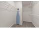A carpeted walk-in closet with wire shelving and an ironing board at 203 Grassy Point Rd, Apex, NC 27502