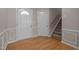Inviting foyer with hardwood floors, classic wainscoting, and a staircase leading to the upper level at 203 Grassy Point Rd, Apex, NC 27502
