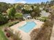 The community pool is surrounded by trees and lawn chairs for residents to enjoy at 203 Grassy Point Rd, Apex, NC 27502