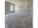 A large living room with a window and unfinished walls is ready for customization at 21 Mildred Pl, Broadway, NC 27505