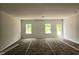 Bright and airy living room area with three large picture windows and a door at 21 Mildred Pl, Broadway, NC 27505