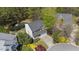 Aerial view of house surrounded by mature trees with beautiful yard and pond at 219 Arbordale Ct, Cary, NC 27518