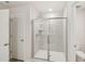 Bathroom features a tiled shower with a glass enclosure, a white toilet, and a door at 2202 Cherry Creek Rd, Haw River, NC 27258