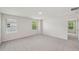 A bright bedroom with two windows and neutral carpeting offers a tranquil space at 2202 Cherry Creek Rd, Haw River, NC 27258