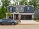 Two-story home with a two-car garage, red door, and gray and blue siding at 2202 Cherry Creek Rd, Haw River, NC 27258