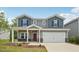 Charming two-story home featuring a two-car garage, red door, and a cozy front porch at 2202 Cherry Creek Rd, Haw River, NC 27258