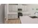 Kitchen features stainless steel appliances, white cabinets, quartz countertops, a subway tile backsplash, and an island with a sink at 2202 Cherry Creek Rd, Haw River, NC 27258