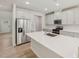 Bright kitchen boasts stainless steel appliances, white cabinets, quartz countertops, and an island with a sink at 2202 Cherry Creek Rd, Haw River, NC 27258