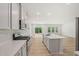 Bright kitchen boasts stainless steel appliances, white cabinets, quartz countertops, and an island with a sink and a subway tile backsplash at 2202 Cherry Creek Rd, Haw River, NC 27258
