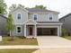 New construction two-story home featuring gray siding, a red front door, and an attached two-car garage at 2206 Cherry Creek Rd, Haw River, NC 27258