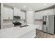 Well-lit kitchen boasts stainless steel appliances, quartz counters, subway tile backsplash, and white cabinets at 2206 Cherry Creek Rd, Haw River, NC 27258