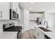 Modern kitchen features stainless steel appliances, white cabinets, quartz countertops, and wood flooring at 2206 Cherry Creek Rd, Haw River, NC 27258