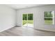 Bright, empty living space with wood-look flooring, sliding glass doors to the yard, and a large window at 2206 Cherry Creek Rd, Haw River, NC 27258