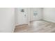 Bright, empty living space with wood-look flooring, a white door, and a large window, ready for personalization at 2206 Cherry Creek Rd, Haw River, NC 27258