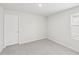 A clean, carpeted bedroom featuring a window with blinds and a white door at 2210 Cherry Creek Rd, Haw River, NC 27258