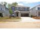Two-story home featuring gray siding, a covered entryway, attached garage, and freshly installed lawn at 2210 Cherry Creek Rd, Haw River, NC 27258