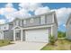 Two-story home featuring gray siding, a two-car garage and a covered front porch at 2210 Cherry Creek Rd, Haw River, NC 27258
