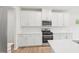 Modern kitchen featuring stainless steel appliances, white cabinets, quartz countertops, and a tile backsplash at 2210 Cherry Creek Rd, Haw River, NC 27258