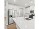 Contemporary kitchen showcasing stainless steel appliances, a large island with sink, and pristine white cabinetry at 2210 Cherry Creek Rd, Haw River, NC 27258