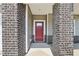 Covered entrance with brick columns, red front door with glass pane, and light gray siding at 2211 Cherry Creek Rd, Haw River, NC 27258