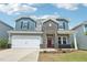 Two-story home with blue and gray siding, brick accents, a two-car garage, and a well-maintained front yard at 2211 Cherry Creek Rd, Haw River, NC 27258