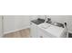 A convenient laundry room features modern washer and dryer units on a wood-look floor at 2211 Cherry Creek Rd, Haw River, NC 27258