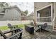 Backyard stone patio with outdoor seating, fire pit, and manicured lawn at 233 Airlie Dr, Chapel Hill, NC 27516