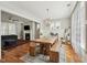 Open-concept dining area featuring a rustic table with bench seating and views to the living room fireplace at 233 Airlie Dr, Chapel Hill, NC 27516