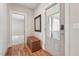 Inviting entryway featuring a hardwood floor, tufted storage bench, and a door with glass paneling at 233 Airlie Dr, Chapel Hill, NC 27516