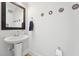 Elegant powder room featuring a pedestal sink, dark wood-framed mirror, and stylish wall decor at 233 Airlie Dr, Chapel Hill, NC 27516