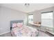 Comfortable and cozy bedroom with neutral carpet, a bed, a desk, and natural light from two windows at 237 Begen St, Morrisville, NC 27560