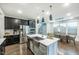 Modern kitchen with stainless steel appliances, island, and open layout to dining area at 237 Begen St, Morrisville, NC 27560