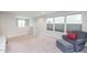 Relaxing living room with soft neutral carpet, chair with ottoman, and natural lighting from multiple windows at 237 Begen St, Morrisville, NC 27560