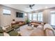 Inviting living room featuring a leather sofa, stylish rug, and modern ceiling fan at 237 Begen St, Morrisville, NC 27560