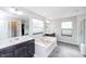 Main bath features soaking tub, dual vanities, walk-in shower and private toilet with tiled floor and natural light at 237 Begen St, Morrisville, NC 27560