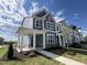 Charming two-story home with blue siding, stone accents, and a welcoming covered front porch at 2401 Whitewing Ln, Wendell, NC 27591