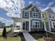 Charming two-story home with blue siding, stone accents, and a welcoming covered front porch at 2401 Whitewing Ln, Wendell, NC 27591