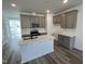 Modern kitchen featuring gray cabinets, a white island, stainless steel appliances and stylish backsplash at 2401 Whitewing Ln, Wendell, NC 27591