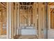 Partially constructed bathroom with tub, showing wood framing and plumbing, awaiting final fixtures and finishes at 2605 Hazelwood Dr, Raleigh, NC 27608
