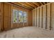 Unfinished bedroom with studs, subfloor, and triple windows, revealing its potential for customization and bright, airy living at 2605 Hazelwood Dr, Raleigh, NC 27608