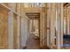 Unfinished hallway displaying exposed studs and subfloor, offering a glimpse into the customizable layout of the home at 2605 Hazelwood Dr, Raleigh, NC 27608
