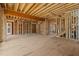 Unfinished room shows exposed studs and beams highlighting open space for design with staircase leading to second floor at 2605 Hazelwood Dr, Raleigh, NC 27608