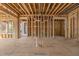 Unfinished living room with exposed studs and beams, ready for customization with pre-wired electricity and backyard access at 2605 Hazelwood Dr, Raleigh, NC 27608