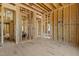 Unfinished living room highlighting the home's layout with exposed framing and pre-wired electric, ready for personalized design at 2605 Hazelwood Dr, Raleigh, NC 27608